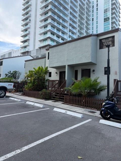 A two-story residential building with a parking lot and a scooter in the foreground — 1901 NW S River Dr # 22C, Miami FL 33125, MIAMI, FL