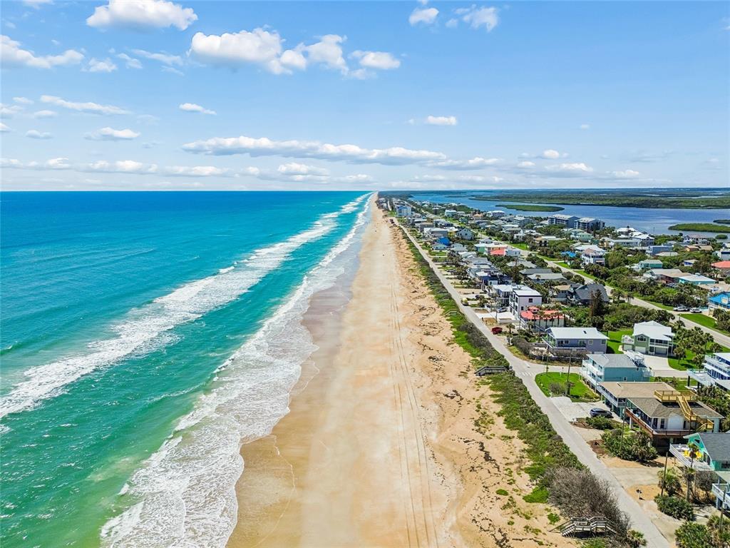 An aerial view shows a sandy beach along the ocean next to coastal residential homes — 6340 ENGRAM ROAD, NEW SMYRNA BEACH, FL