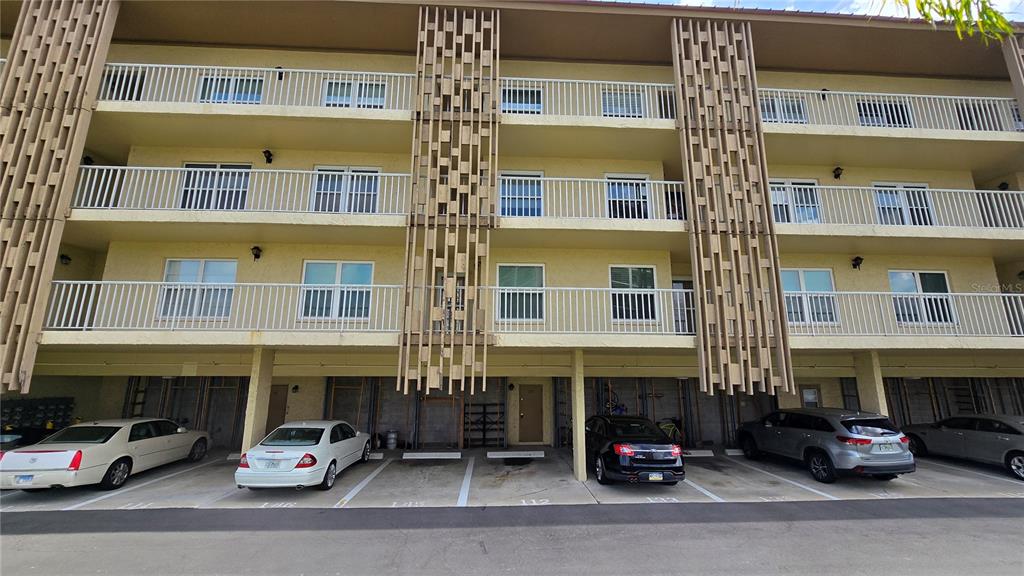 A multi-story apartment building with covered parking spaces on the ground level — 105 ISLAND WAY UNIT 112, CLEARWATER BEACH, FL
