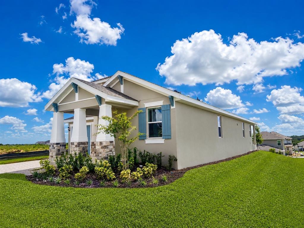 A single-story house with a stone-accented porch, blue shutters, and a green lawn — 2244 AXEL STREET, MINNEOLA, FL