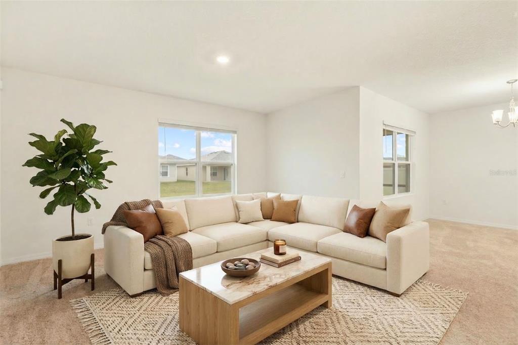 A living room features a beige sectional sofa, a marble-topped coffee table, and a potted plant — 943 SUMMER GLEN DRIVE, WINTER HAVEN, FL