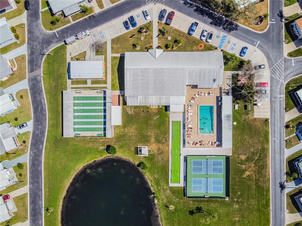Aerial view of a community center with a pool, tennis courts, and shuffleboard courts — 2900 8TH AVENUE W UNIT 18, PALMETTO, FL
