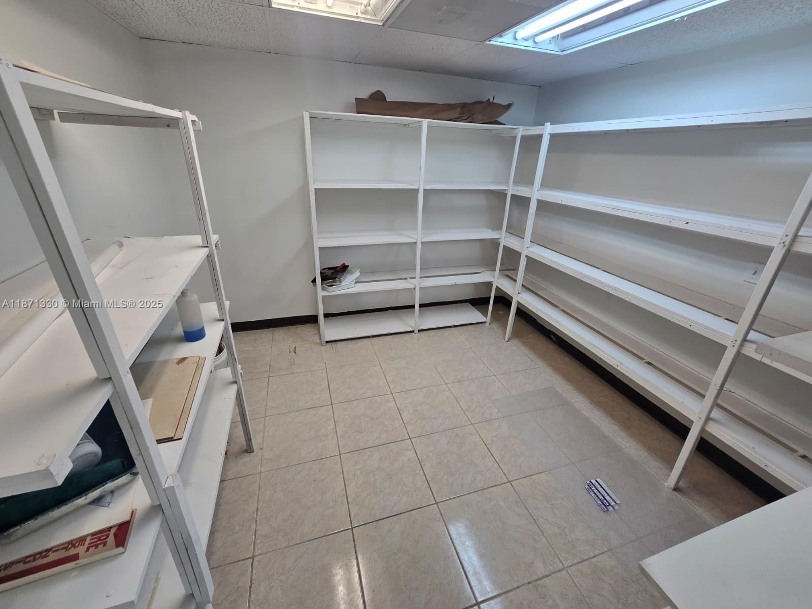 A small storage room features white shelving units against the walls and tiled flooring — 2501 N State Road 7 # 216, Margate FL 33063, MARGATE, FL