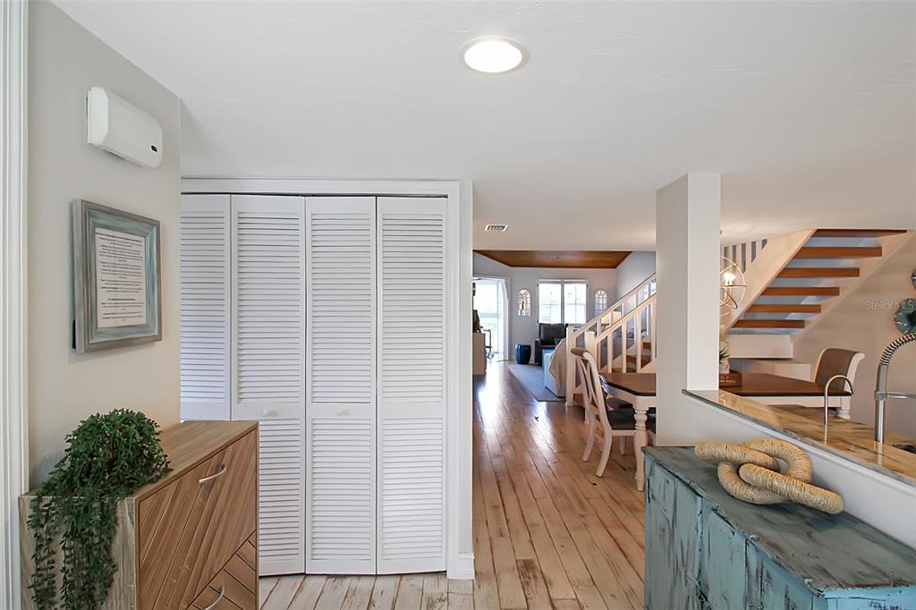 A view from a hallway looking into a living area with white louvered closet doors — 1315 SIESTA BAYSIDE DRIVE UNIT 1315B, SARASOTA, FL