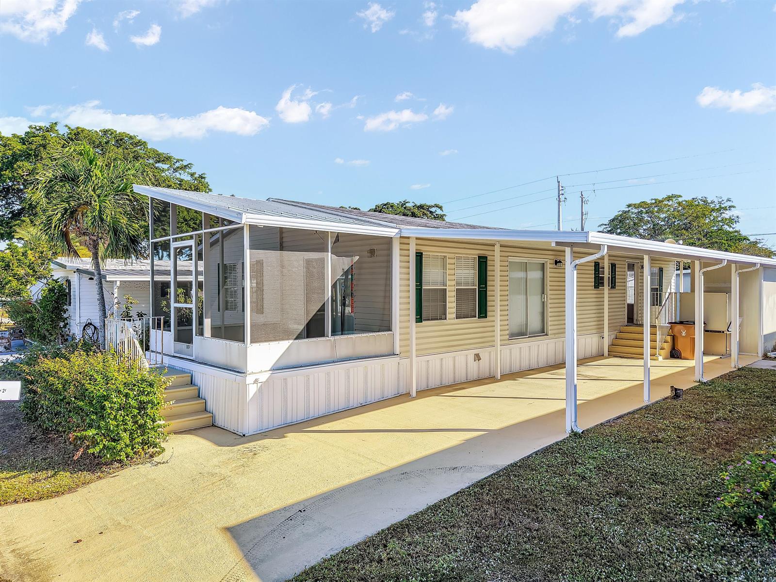 A single-story mobile home features a screened-in porch, a carport, and light-colored siding — 4920 NW 2nd Terrace, Pompano Beach FL 33064, POMPANO BEACH, FL