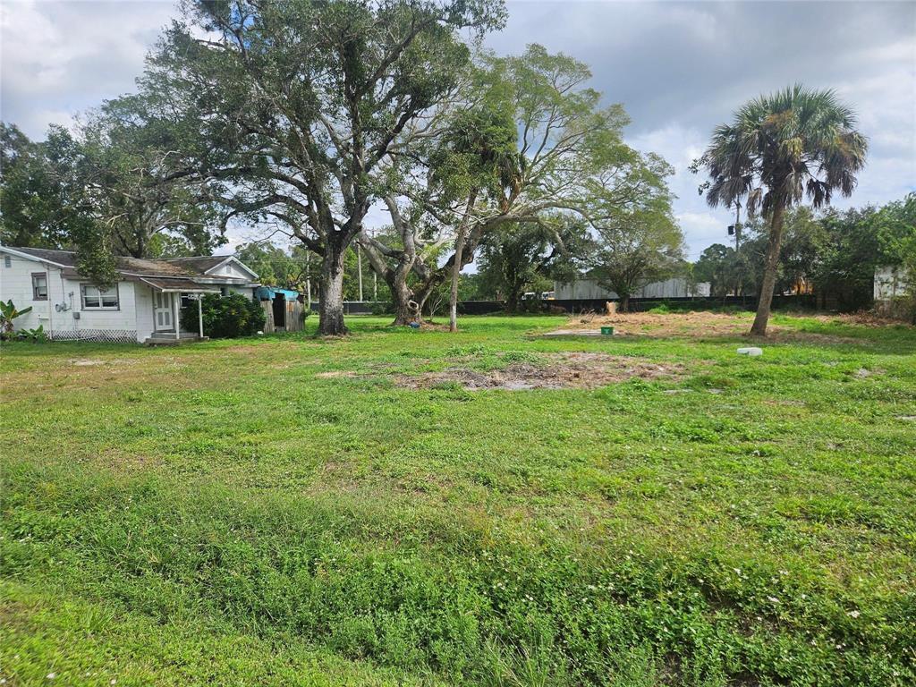 A small white house sits on a large, grassy lot with several mature trees — 5299 St Lucie Boulevard, Fort Pierce FL 34946, FORT PIERCE, FL