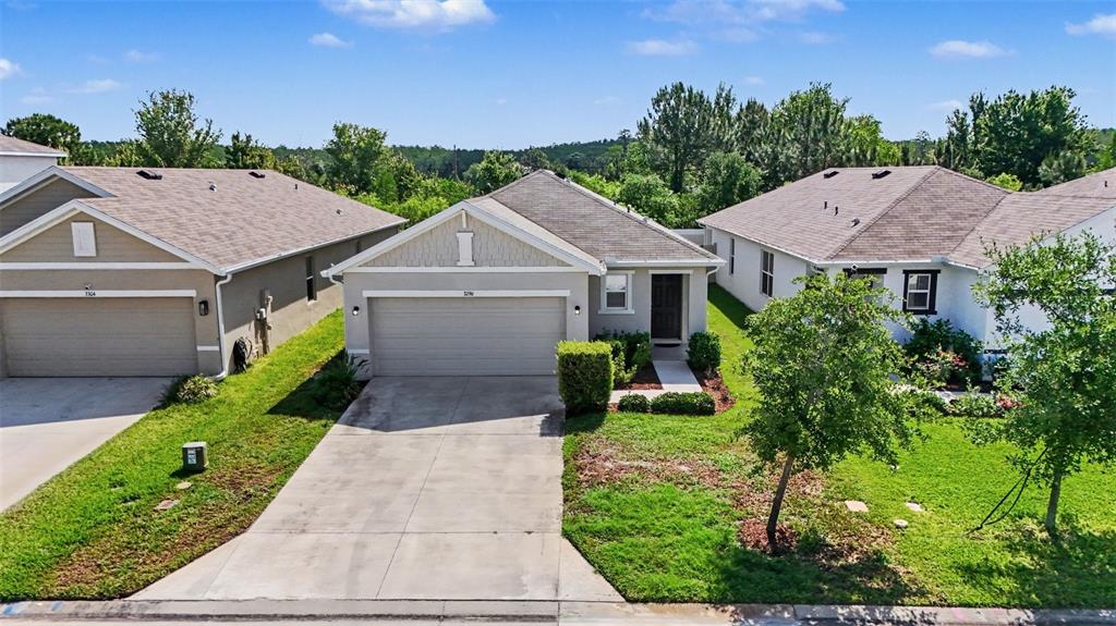 An exterior view of a suburban single-story house with a concrete driveway and attached garage — 3296 SUNCOAST PLAINS DRIVE, ODESSA, FL