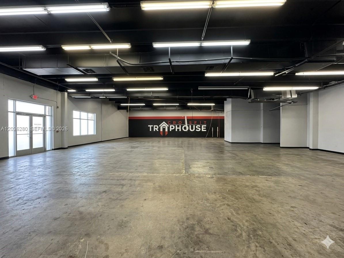 An empty commercial space features a concrete floor, black ceiling, and a CrossFit Traphouse logo — 590 SW 9th Ter # 11, Pompano Beach FL 33069, POMPANO BEACH, FL