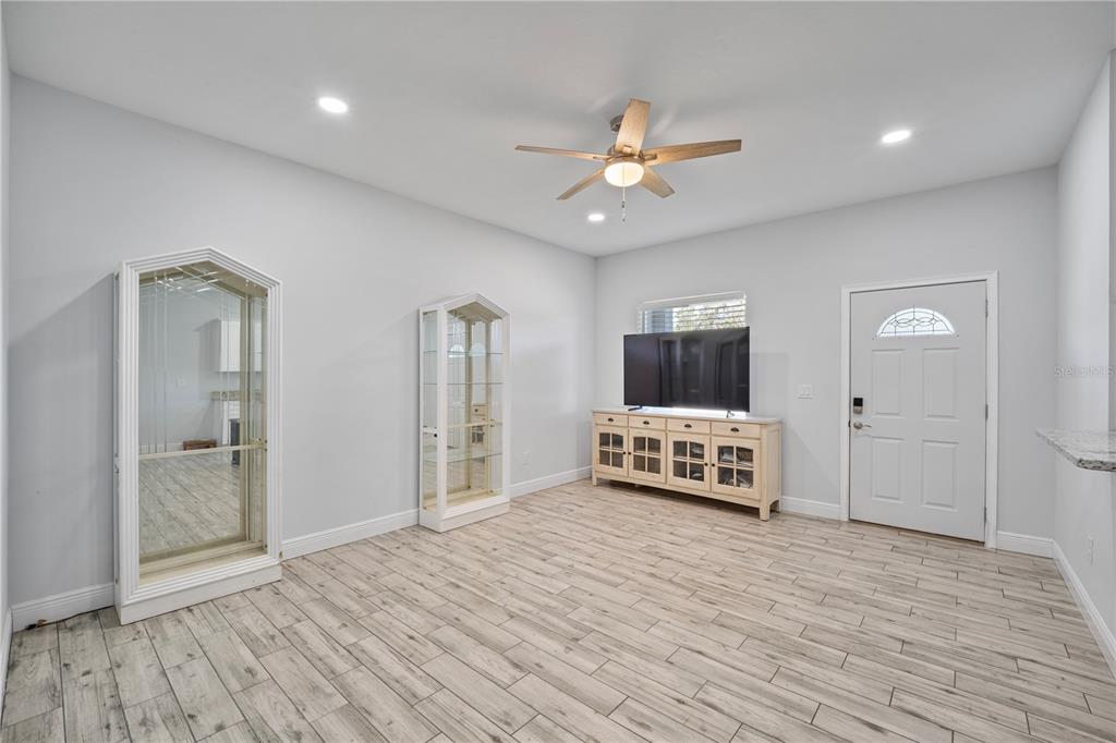 A living room features light wood-look tile flooring, a ceiling fan, and a white door — 3842 PHILLIPS ROAD, LAKE WALES, FL