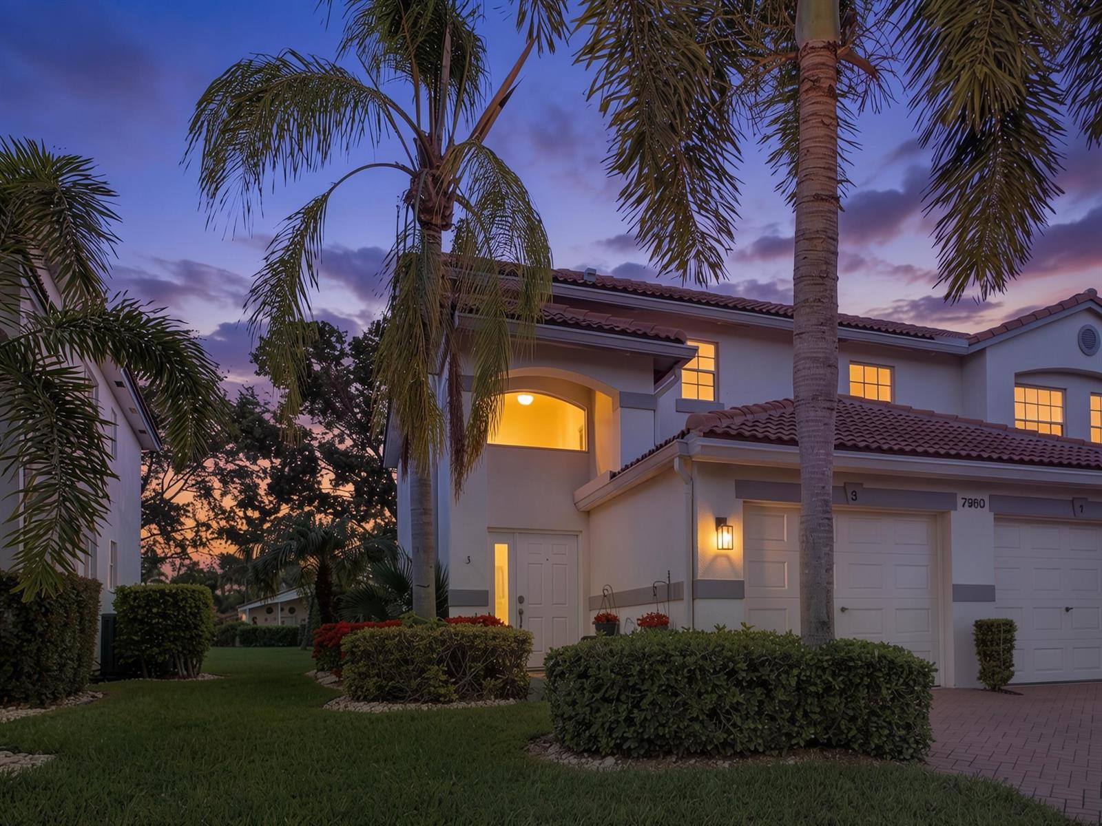 A two-story stucco house with a tiled roof and palm trees at dusk — 7960 Laina Lane Unit 3, Boynton Beach FL 33437, BOYNTON BEACH, FL
