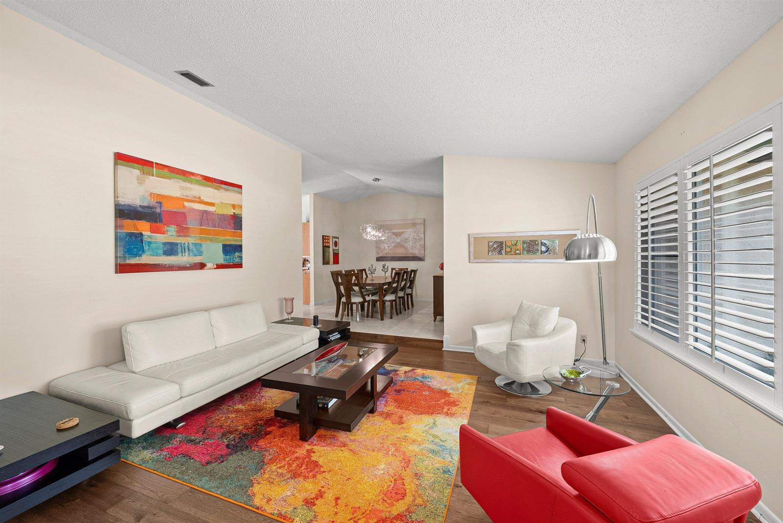 A living room features a white sofa, a red armchair, and a colorful area rug — 2493 Timbercreek Circle NW, Boca Raton FL 33431, BOCA RATON, FL