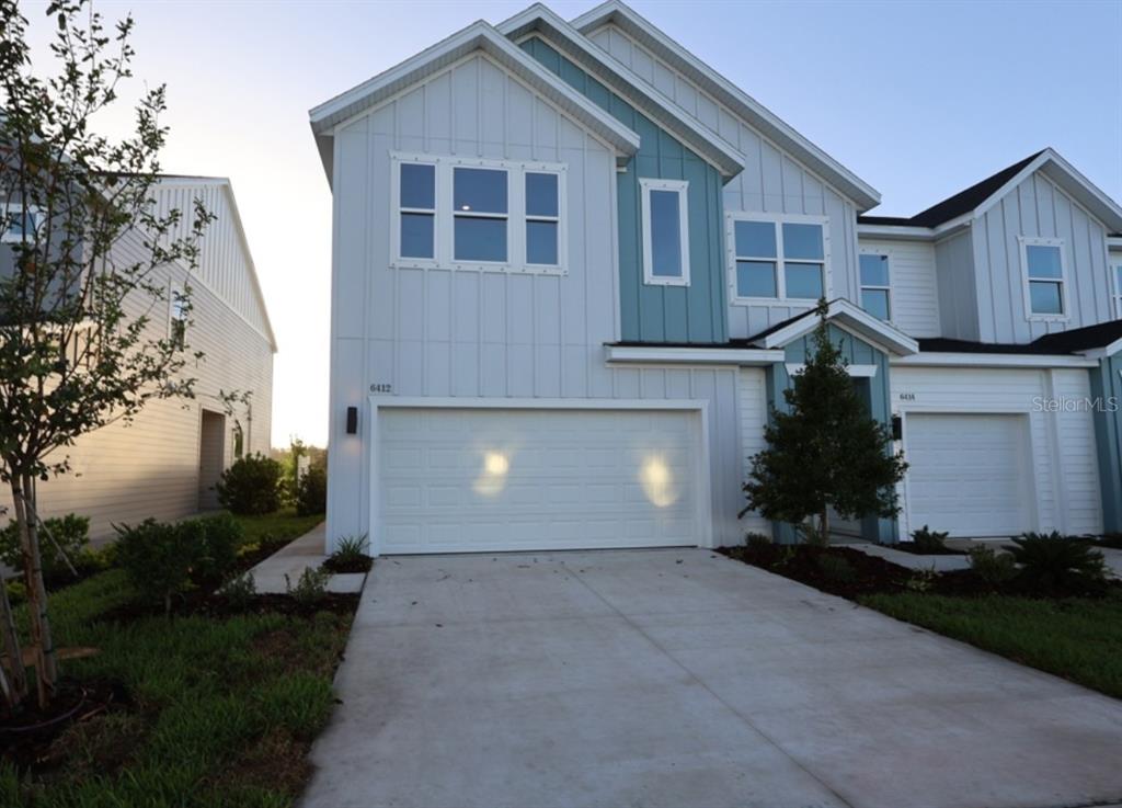 A two-story house with white vertical siding, blue accents, and a two-car garage — 6412 JENSEN VIEW AVENUE, APOLLO BEACH, FL