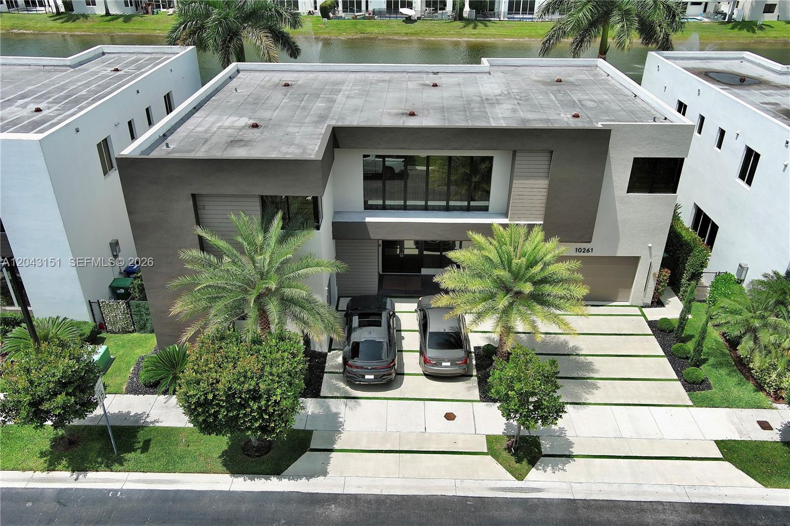An aerial view shows a modern two-story house with a flat roof and driveway — 10261 NW 74th Ter # 10261, Doral FL 33178, DORAL, FL