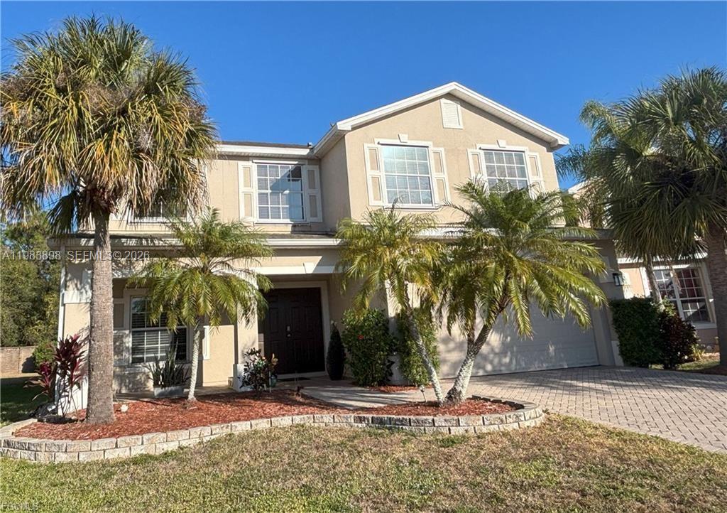 A two-story suburban house with a paved driveway, palm trees, and a front entrance — 8042 Silver Birch Way, Lehigh Acres FL 33971, LEHIGH ACRES, FL