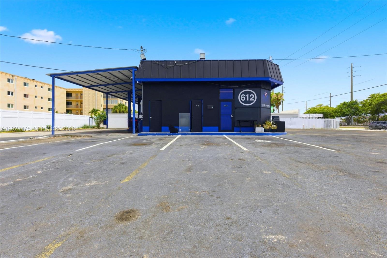 A black and blue commercial building with a covered parking area and asphalt lot — 612 N Dixie Hwy, Hollywood FL 33020, HOLLYWOOD, FL
