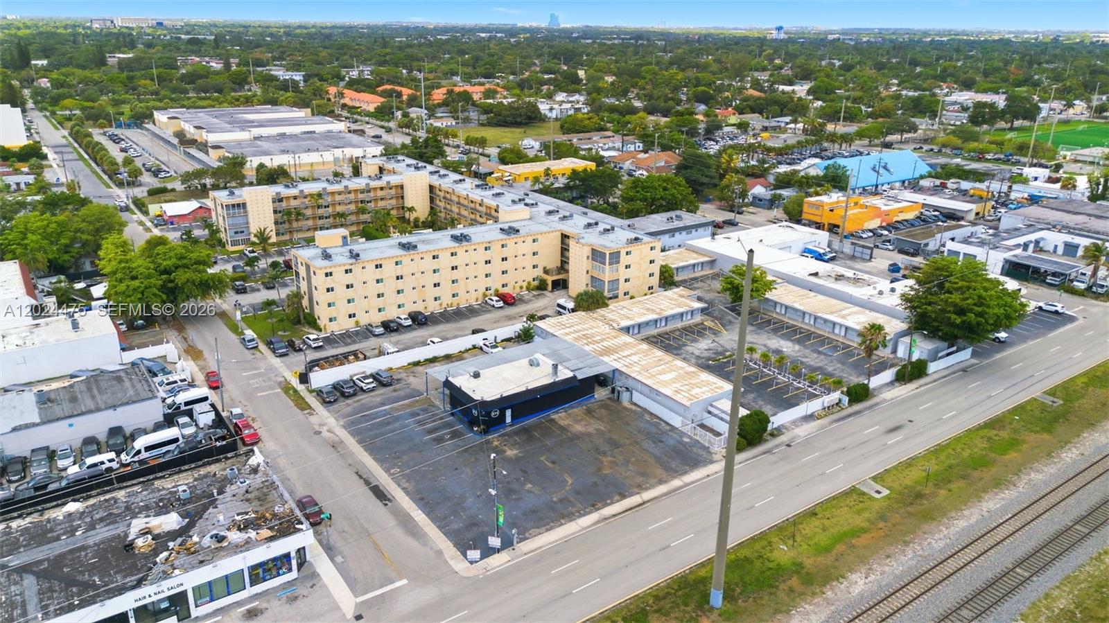An aerial view shows a multi-story apartment complex with adjacent parking lots and commercial buildings — 612 N Dixie Hwy, Hollywood FL 33020, HOLLYWOOD, FL