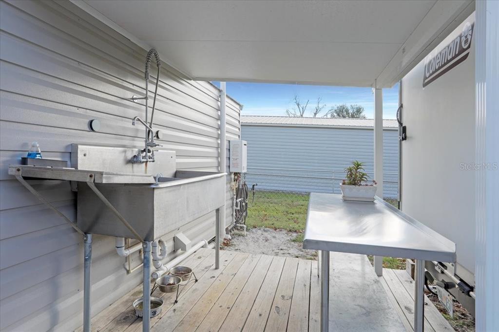 An outdoor covered area features a stainless steel utility sink and a metal prep table — 5336 SW COUNTY ROAD 791, LAKE BUTLER, FL