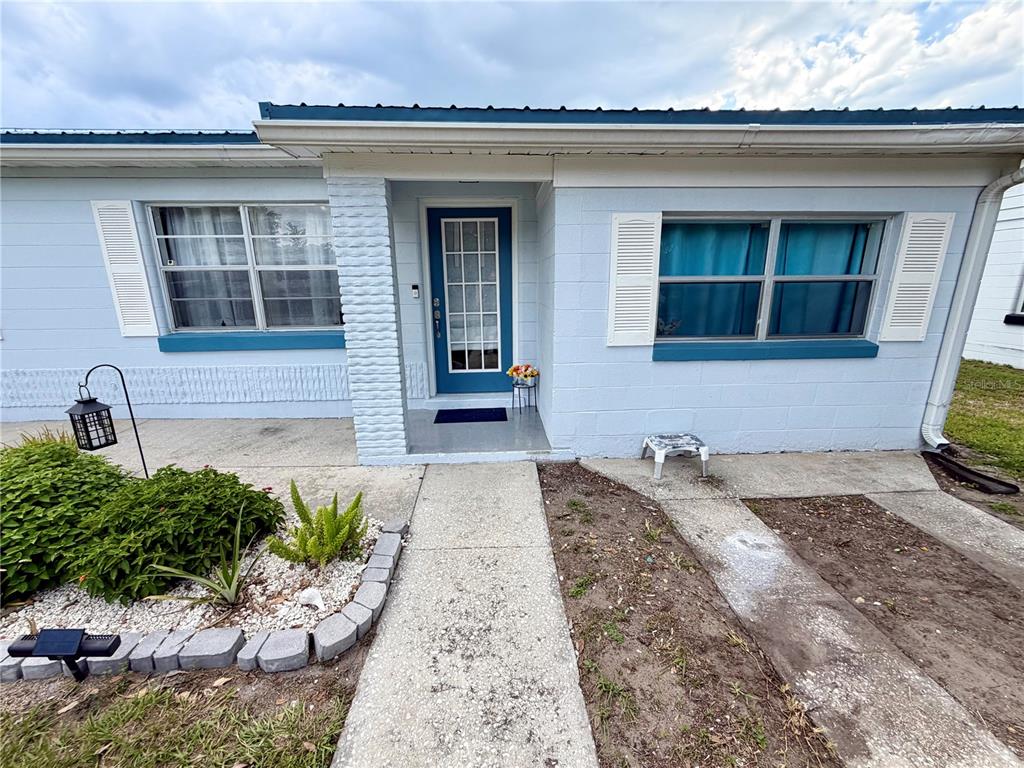 A light blue single-story house exterior features a front door, windows with shutters, and walkway — 1185 S JOHNSON AVENUE, BARTOW, FL