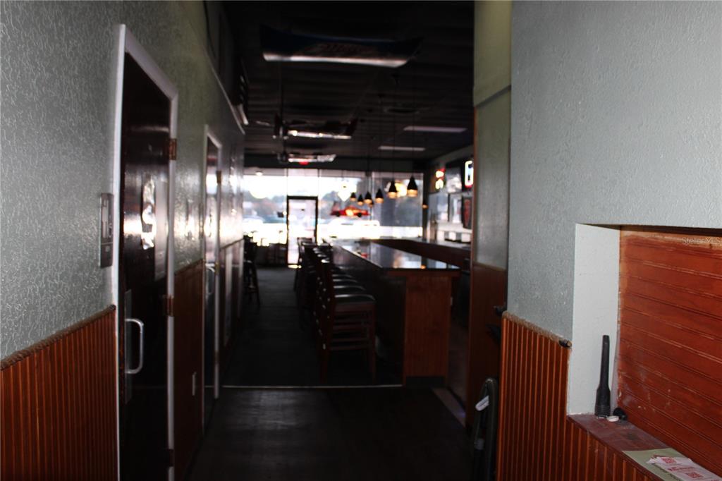 A narrow hallway leads to a bar area with stools and pendant lighting — 6636 RIDGE ROAD, PORT RICHEY, FL