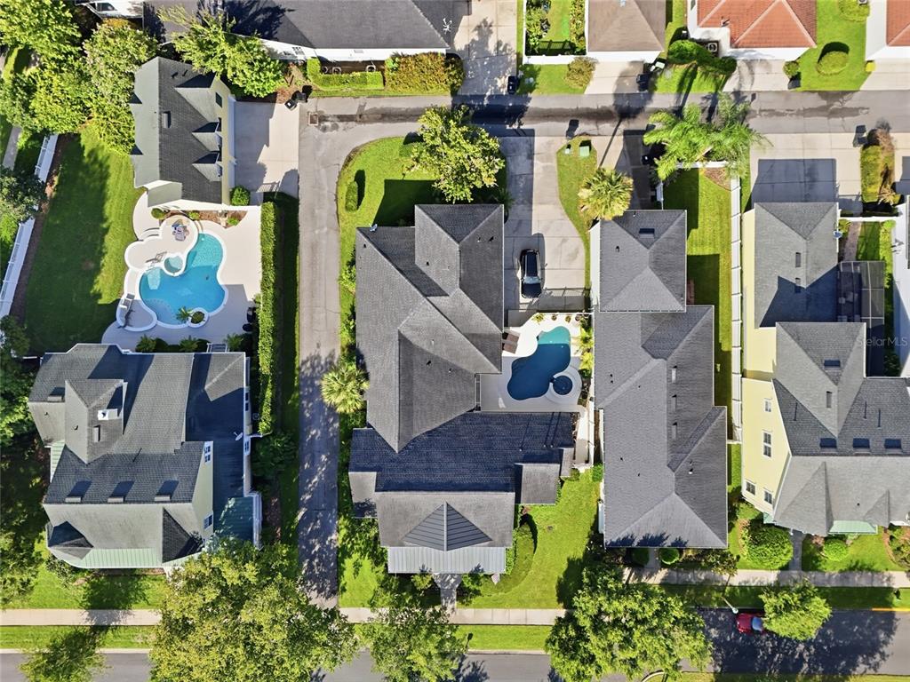 An aerial view shows a backyard with a swimming pool, a spa, and lounge chairs — 1018 WILD ELM STREET, CELEBRATION, FL