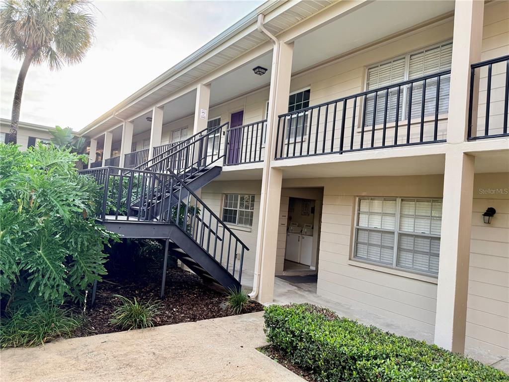 An exterior view of a two-story apartment building with metal stairs and a palm tree — 2207 S CAROLINA AVENUE UNIT 33, TAMPA, FL