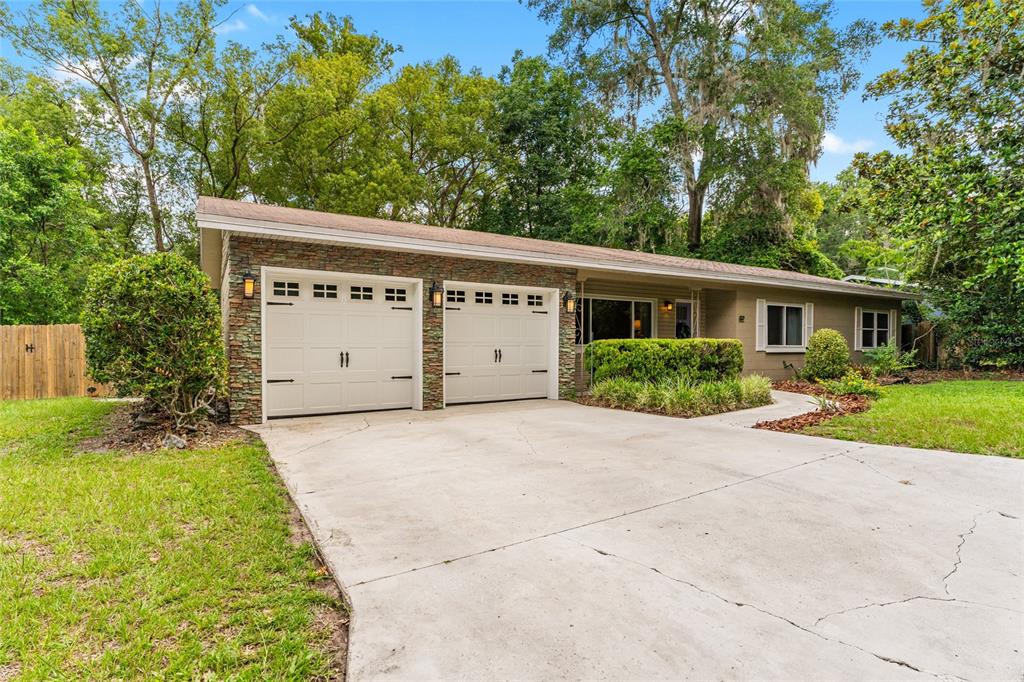 A single-story house with a two-car garage, stone facade, and a concrete driveway — 3224 NW 31ST AVENUE, GAINESVILLE, FL