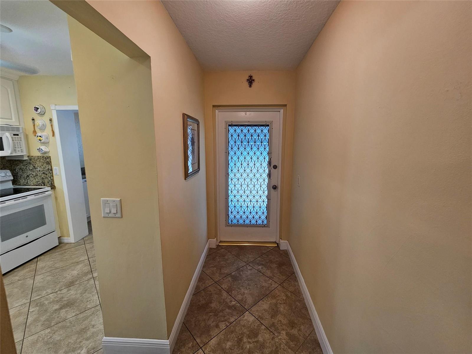 A tiled entryway leads to a white front door with a decorative metal security screen — 6650 Royal Palm Boulevard # 315c, Margate FL 33063, MARGATE, FL