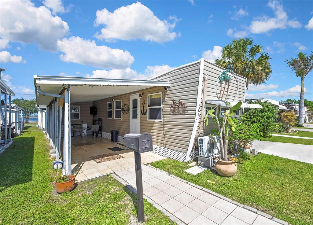 A single-story mobile home with a carport, tiled walkway, and a mailbox in the front — 800 32ND AVENUE S UNIT 606, ST PETERSBURG, FL