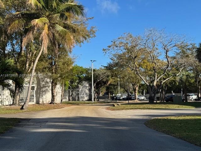 An exterior view of a residential building with palm trees and a paved driveway — 10353 N Kendall Dr # 6, Miami FL 33176, MIAMI, FL