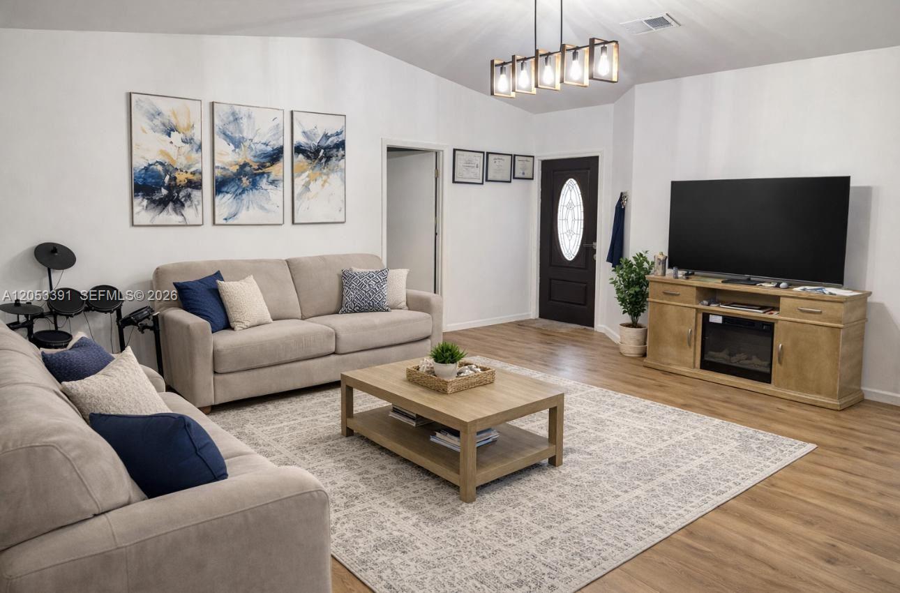 A living room features two beige sofas, a wooden coffee table, and a television console — 9821 W Elm Ln # 9821, Miramar FL 33025, MIRAMAR, FL