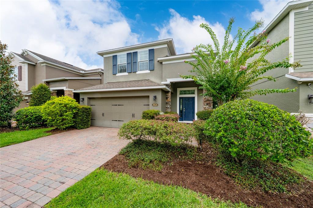 A two-story suburban house with a paved driveway, a two-car garage, and landscaped front yard — 5924 PAXTON COURT, APOPKA, FL