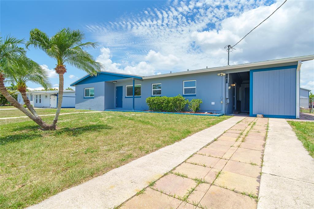A blue single-story house with a paved driveway and a palm tree in the yard — 138 BUCKEYE AVENUE NW, PORT CHARLOTTE, FL