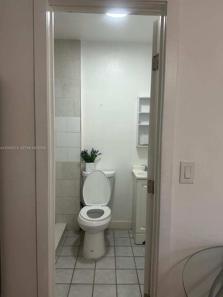 A small bathroom features a white toilet, a pedestal sink, and light-colored tiled flooring — 19301 SW 220th St # 0, Miami FL 33170, MIAMI, FL