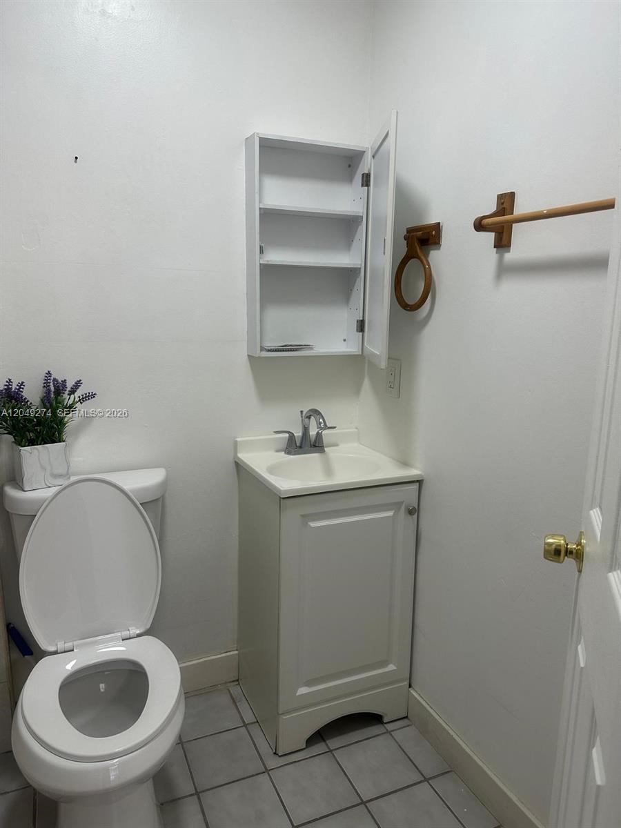 A small bathroom features a white vanity, a wall-mounted cabinet, and a toilet — 19301 SW 220th St # 0, Miami FL 33170, MIAMI, FL
