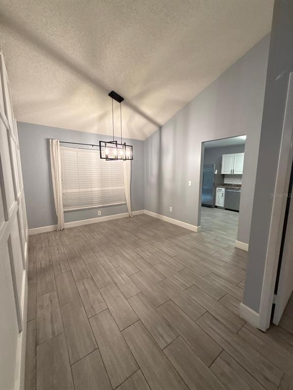 A dining room with light gray walls, wood-look tile flooring, and a modern pendant light — 1215 TUXFORD DRIVE, BRANDON, FL