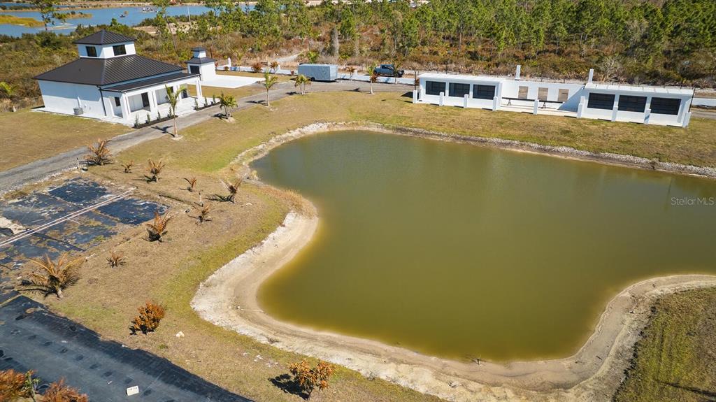 An aerial view shows a white house, a detached garage, and a pond — 30000 BERMONT ROAD, PUNTA GORDA, FL