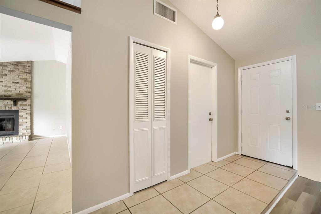 An entryway features beige tile flooring, a white front door, and two closet doors — 717 LANCEWOOD DRIVE, WINTER SPRINGS, FL