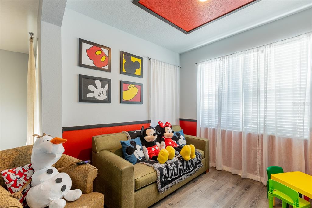 A child's bedroom features a green sofa, Mickey Mouse decor, and a large Olaf plush toy — 891 ASSEMBLY COURT, REUNION, FL
