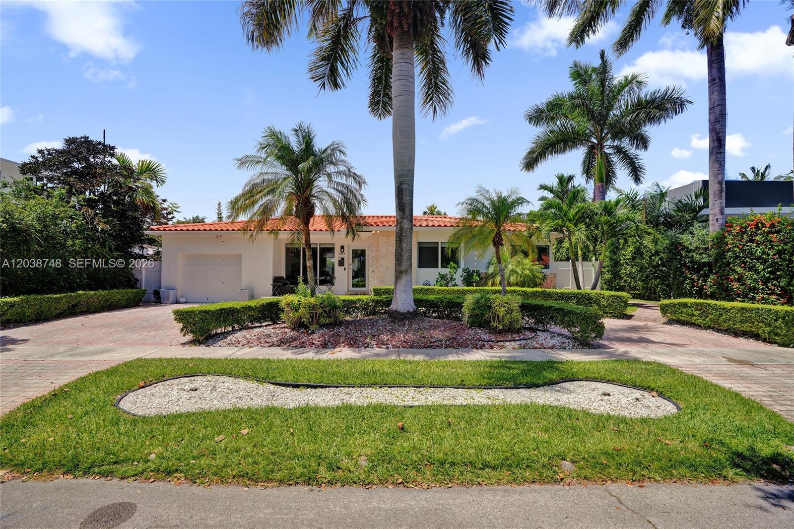 A single-story house with a red tile roof, palm trees, and a landscaped front yard — 2025 Alamanda Dr, North Miami FL 33181, NORTH MIAMI, FL