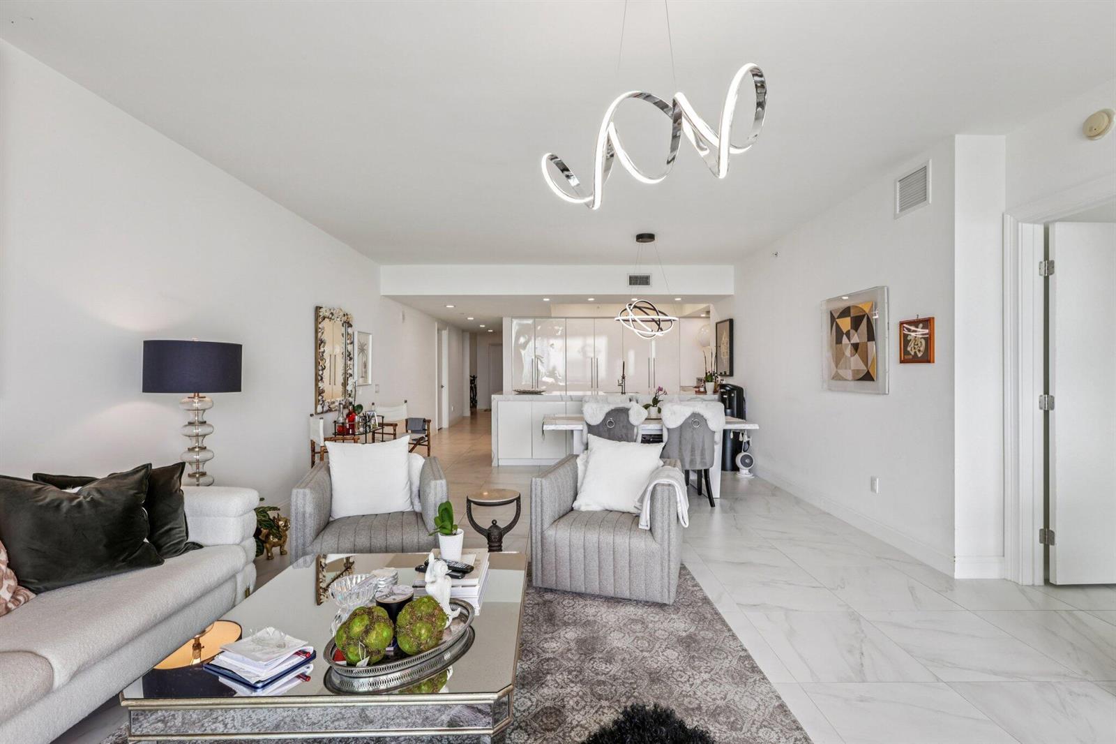 A modern living room and dining area with white tile floors and contemporary light fixtures — 2640 Lake Shore Drive # 2008, Riviera Beach FL 33404, RIVIERA BEACH, FL