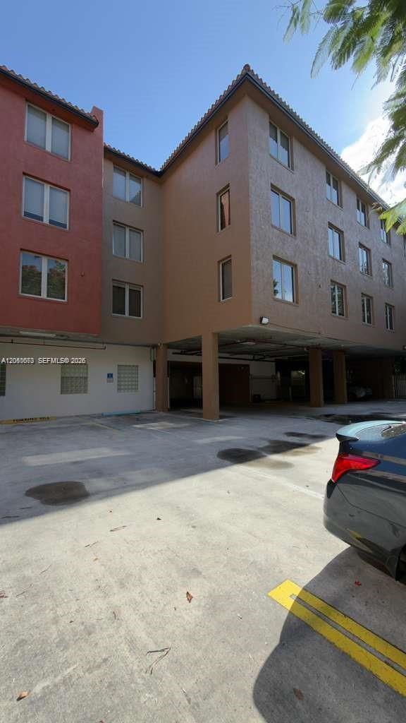 An exterior view of a multi-story apartment building with a covered parking area below — 2630 SW 28th St # 34, Miami FL 33133, MIAMI, FL