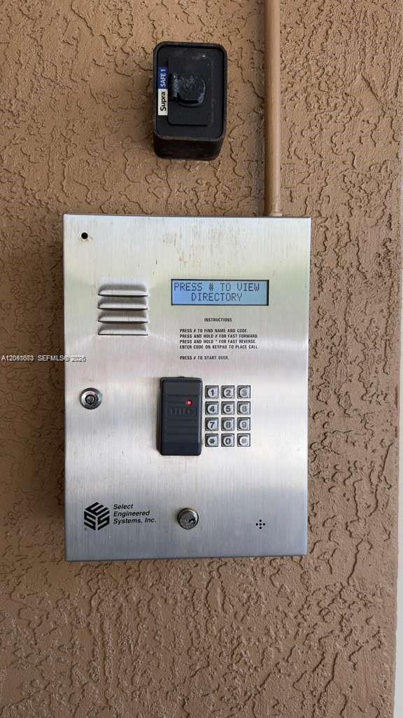 A metal intercom system with a keypad and directory screen is mounted on a stucco wall — 2630 SW 28th St # 34, Miami FL 33133, MIAMI, FL