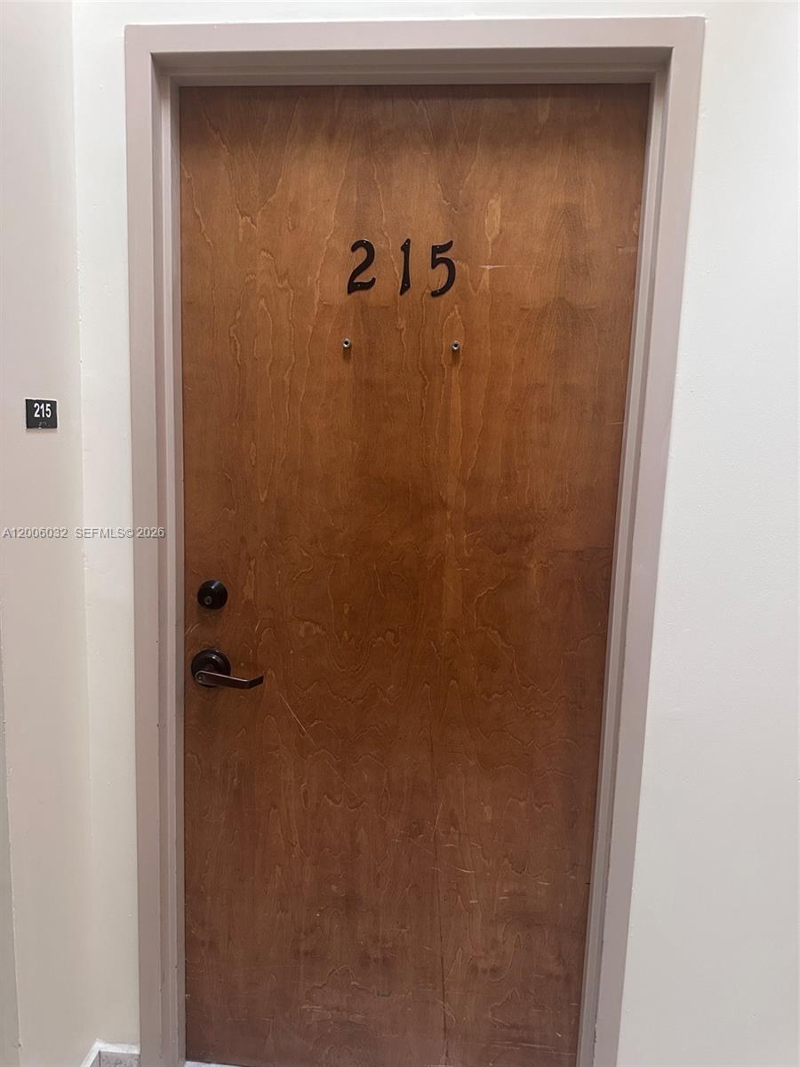 A wooden door with the number 215 is set within a white wall — 5455 SW 8 ST # 215, Miami FL 33134, MIAMI, FL