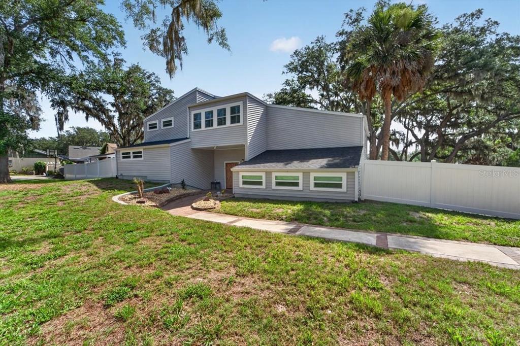 A two-story house with gray siding features a walkway leading to the front entrance — 11302 SANDPINE ROAD, RIVERVIEW, FL