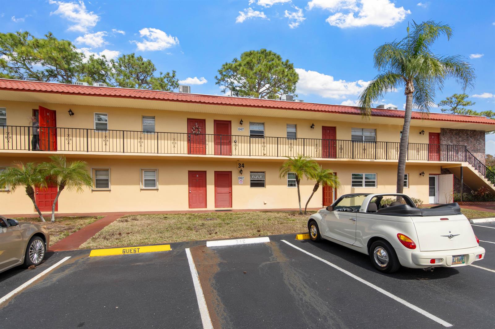 A two-story apartment building with a red roof, yellow exterior, and a parking lot — 1967 SW Palm City Road # h, Stuart FL 34994, STUART, FL