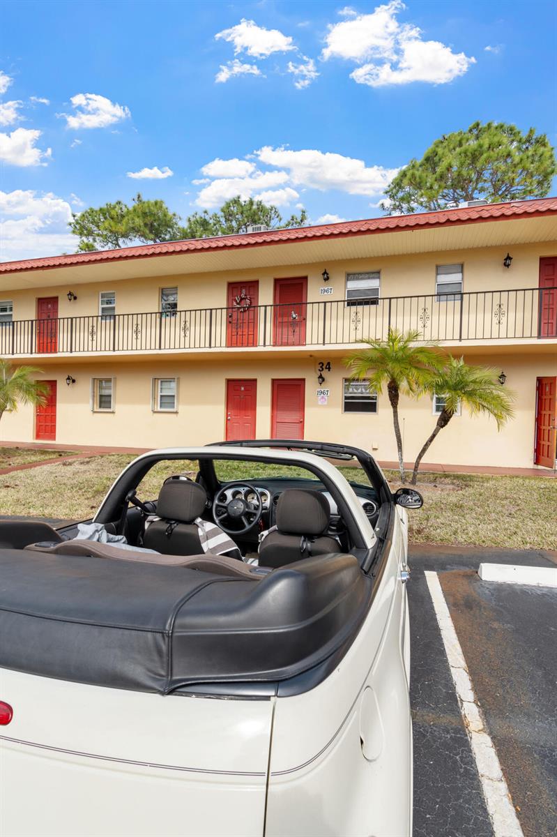 A white convertible car is parked in front of a two-story apartment building — 1967 SW Palm City Road # h, Stuart FL 34994, STUART, FL