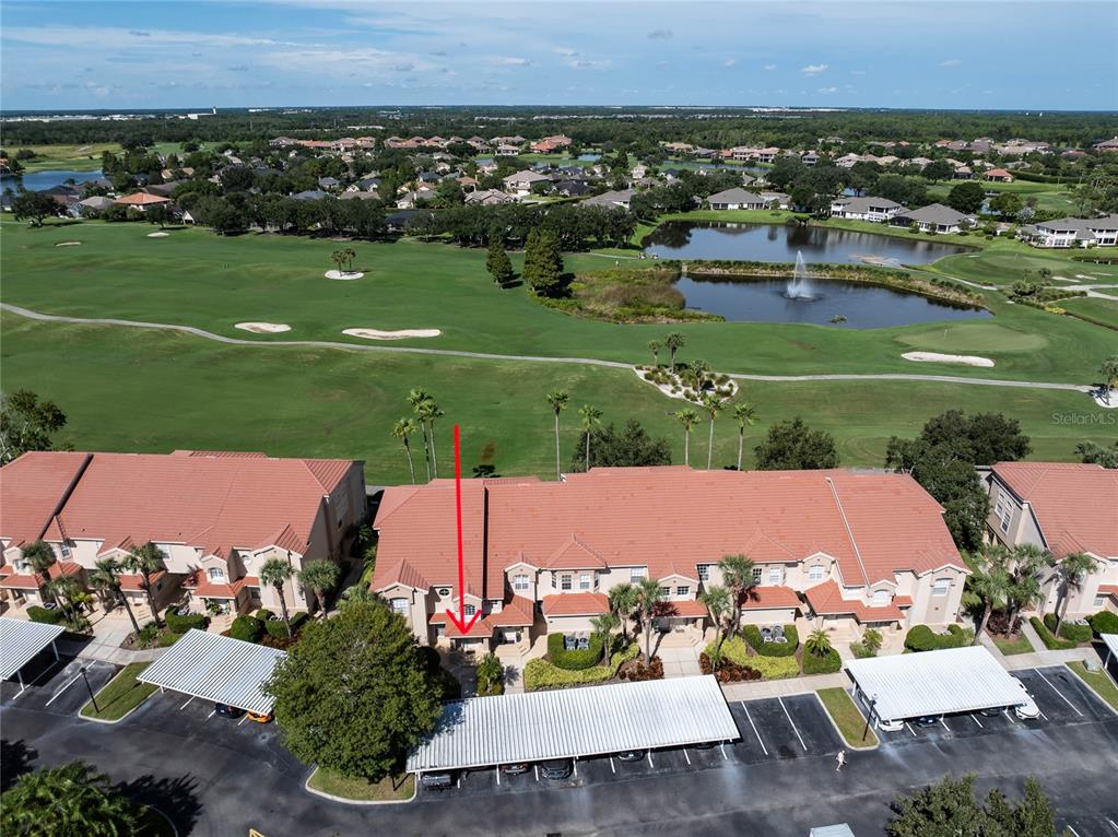 An aerial view shows a multi-unit townhouse complex with a red arrow pointing to one entrance — 447 ENCLAVE PLACE UNIT 447, LAKELAND, FL