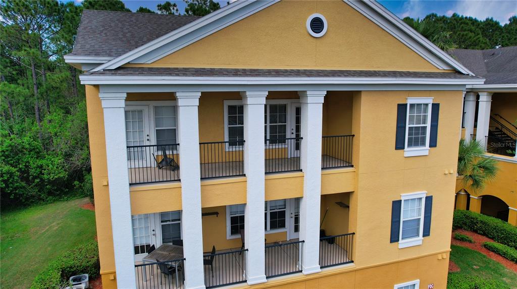 An exterior view of a yellow multi-story building featuring two levels of covered balconies — 3757 CONROY RD UNIT 2531, ORLANDO, FL