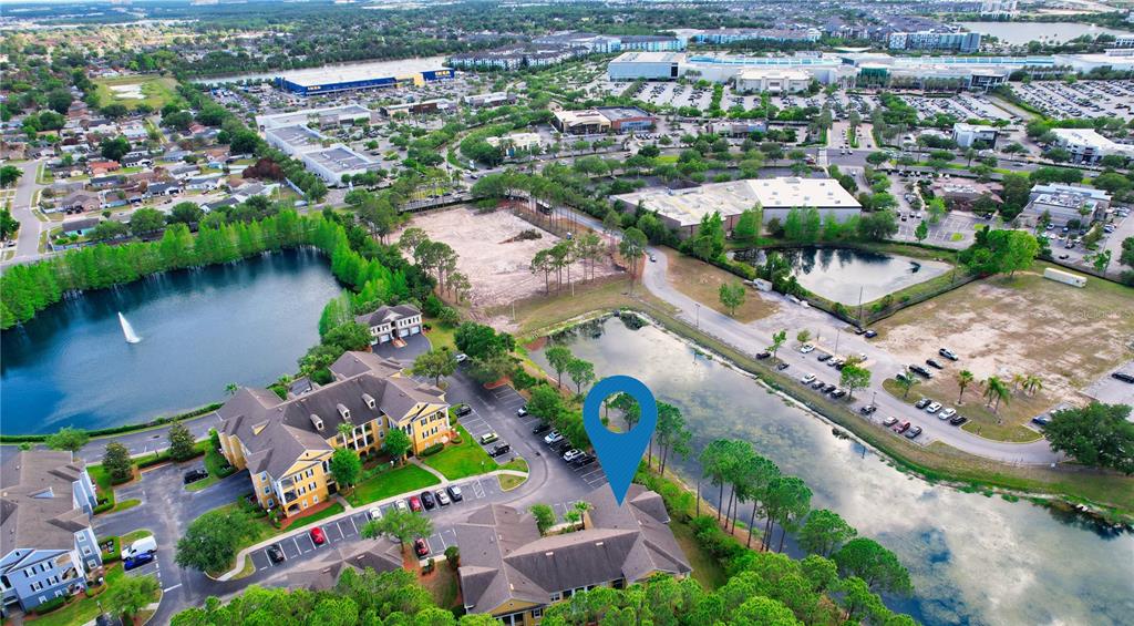 An aerial view shows apartment buildings, parking lots, and ponds in a suburban area — 3757 CONROY RD UNIT 2531, ORLANDO, FL