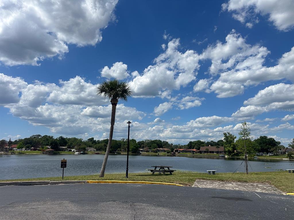 A view of a lake with a palm tree, a picnic table, and houses — 922 LAKE DESTINY ROAD UNIT H, ALTAMONTE SPRINGS, FL